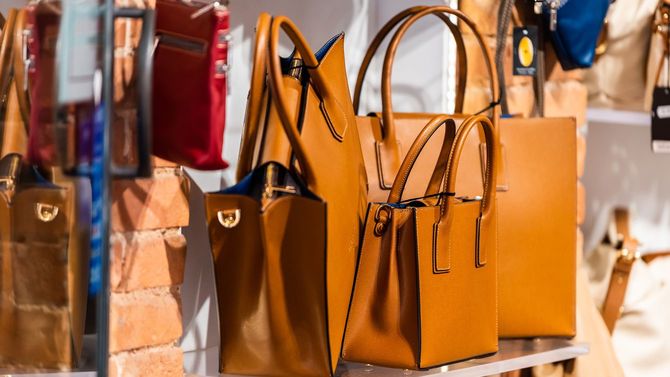 イタリア・シエナの市場にいくつものオレンジブラウンの革製バッグが置かれている