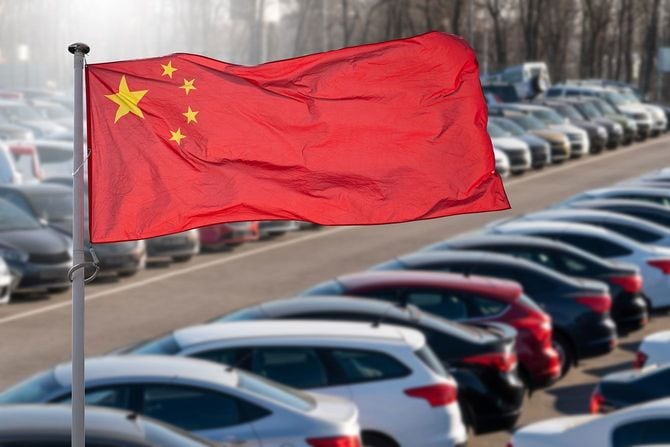 たくさんの車を背景にした中国国旗