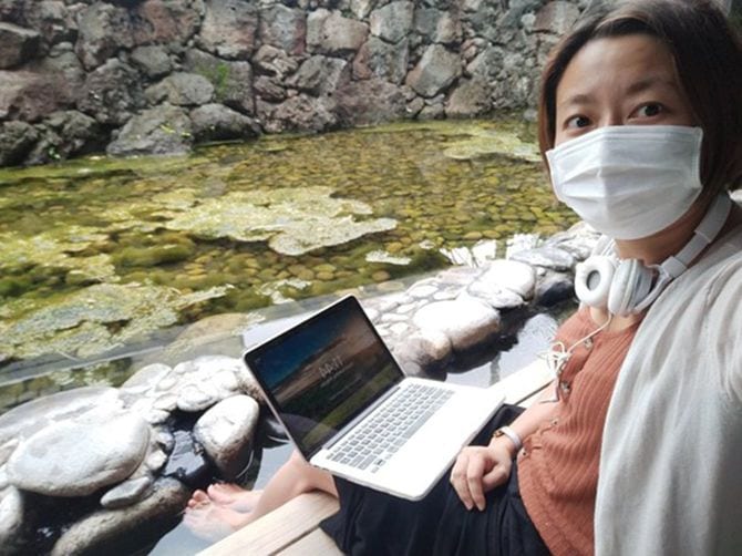 兵庫県の城崎温泉にて。足湯に浸かりながらワークする森山さん。