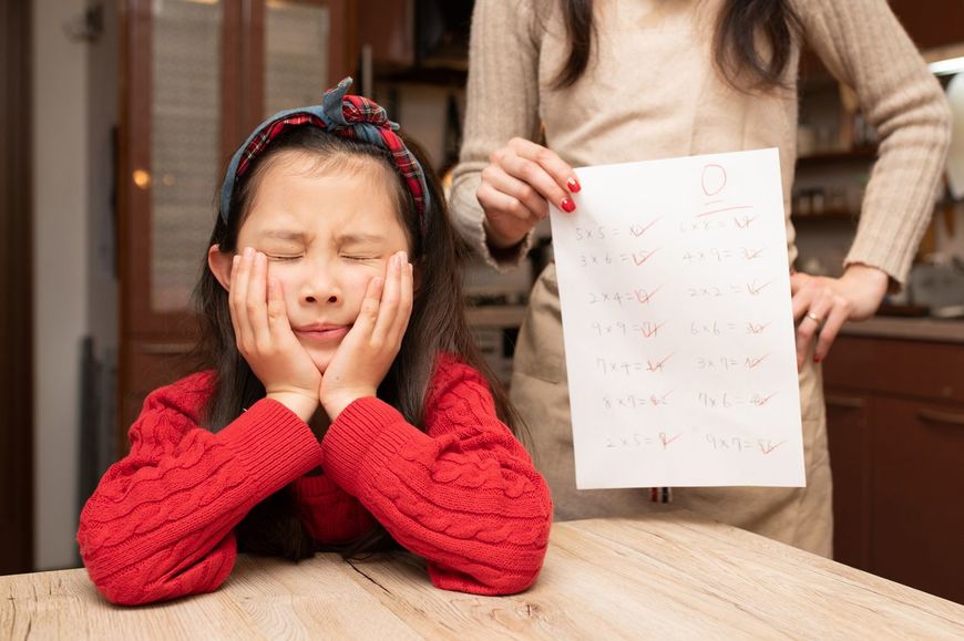 ゼロ点の解答用紙を手に娘を叱る母親