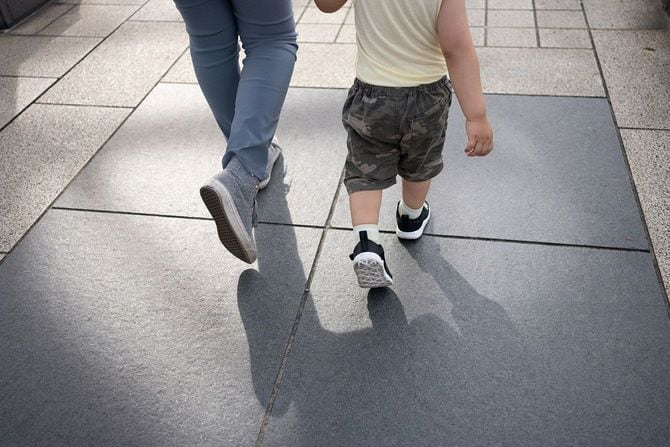 手をつないで歩く母子の後ろ姿