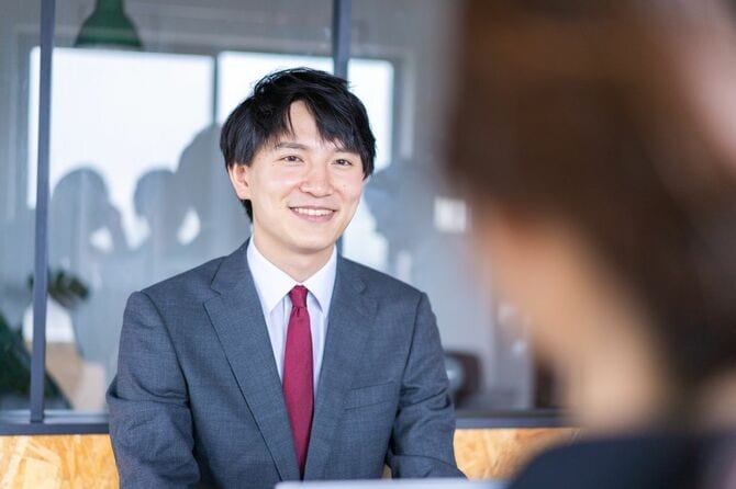 会議で話す若いビジネスパーソン