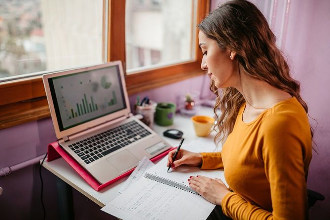 自宅でノートを勉強し、書く学生