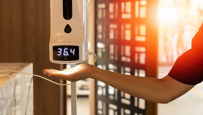 温度測定と手指消毒剤付きのホテルの受付