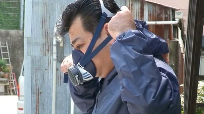特殊清掃の準備に取りかかる筆者。防毒マスクは欠かせない。