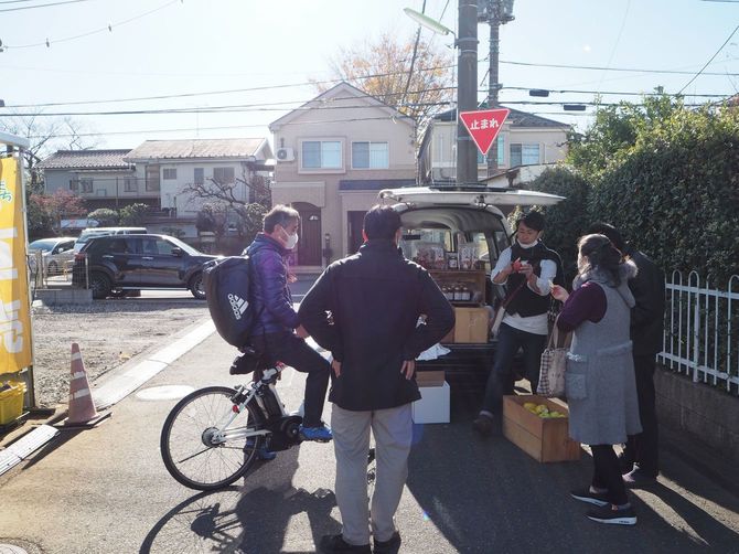 住宅街の道路で片山さんのバンを囲むお客さんたち