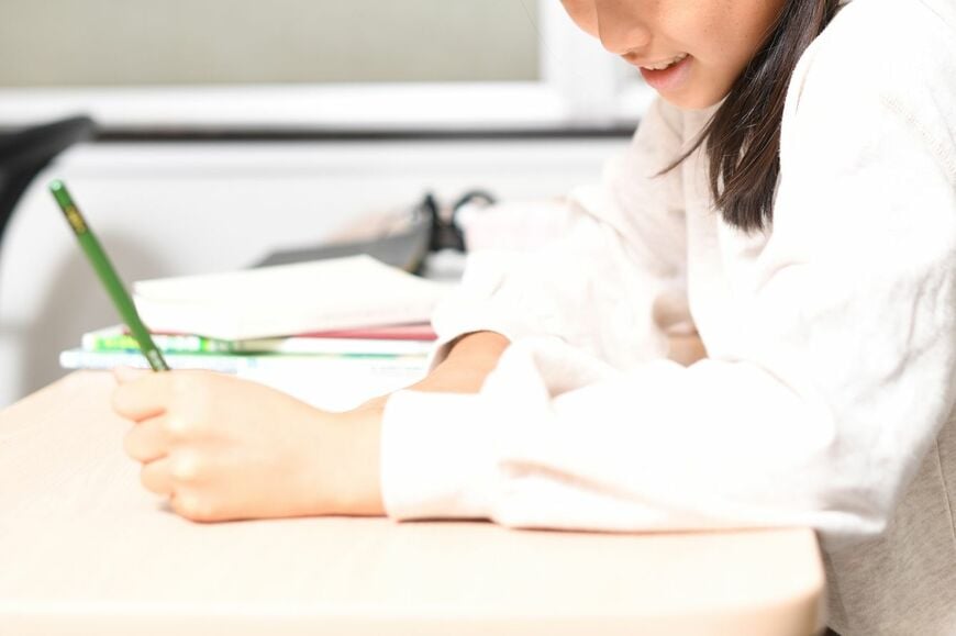左手に鉛筆を持ち、勉強している女の子