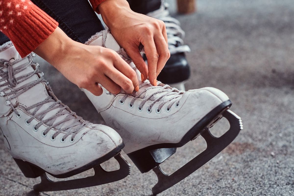 ロッカールームでアイススケートの靴ひもを結ぶ
