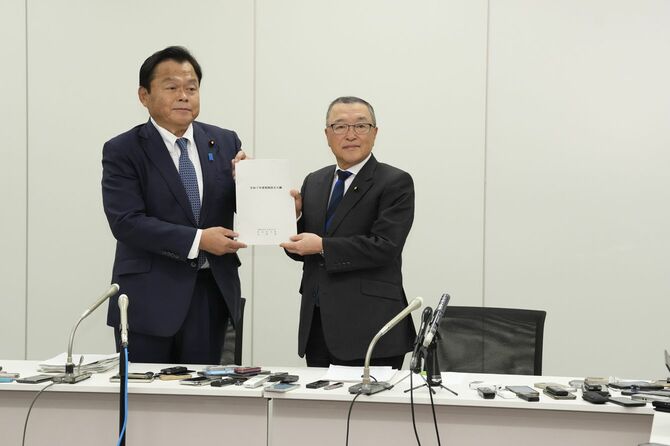 2025年度の与党税制改正大綱を決定し、記者会見で撮影に応じる自民党の宮沢洋一税調会長（右）と公明党の赤羽一嘉税調会長＝2024年12月20日午後、国会