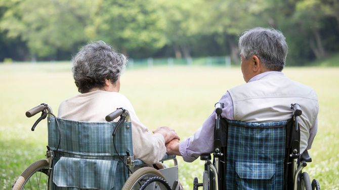 手をつなぐ高齢のカップル