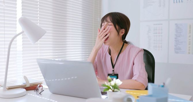 仕事中にあくびをする女性