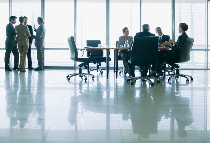 オフィスで会議中のグループと立ち話中のグループ