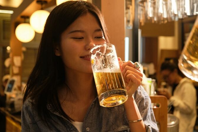 バーでビールを飲むアジアの若い女性
