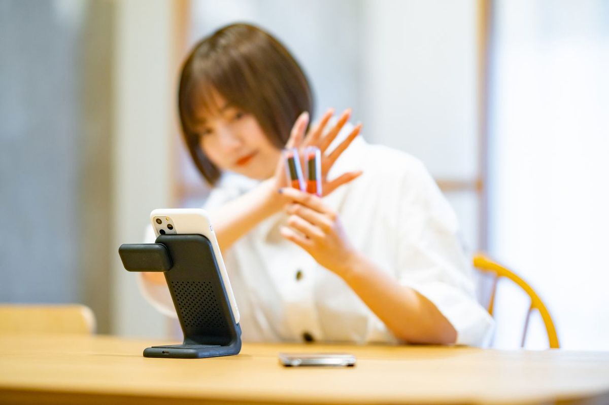 スマートフォンを使って化粧品を紹介する女性