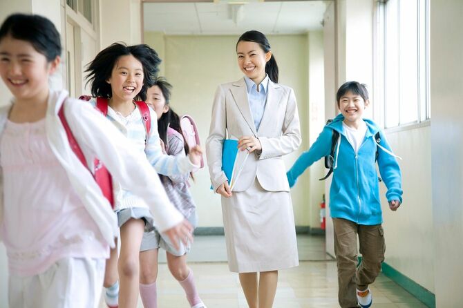 笑顔で学校の廊下を歩く教師と生徒