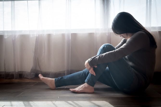 床に座って落ち込んでいる女性