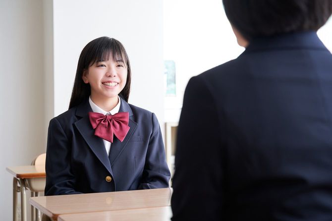 教室で先生と話す女子生徒