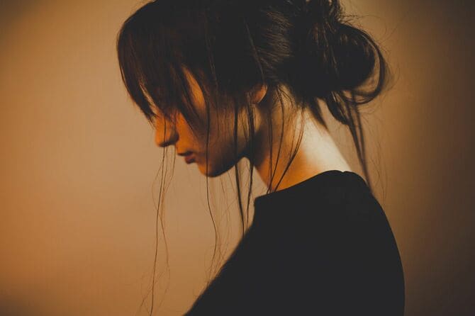 黒い服を着てうつむく女性