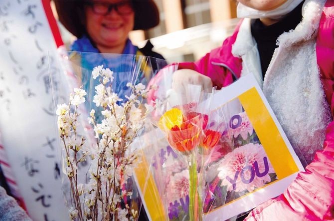名古屋高裁前でプラカードと花束を持つ女性たち。性暴力の撲滅を訴える「フラワーデモ」が始まるきっかけの1つになった無罪判決は、この撮影直後に逆転有罪となった。2020年3月、筆者撮影。