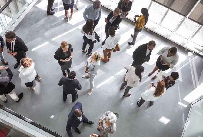 ワーキングイベントで、多様な人々がそれぞれ小さなグループで立ち話をしている