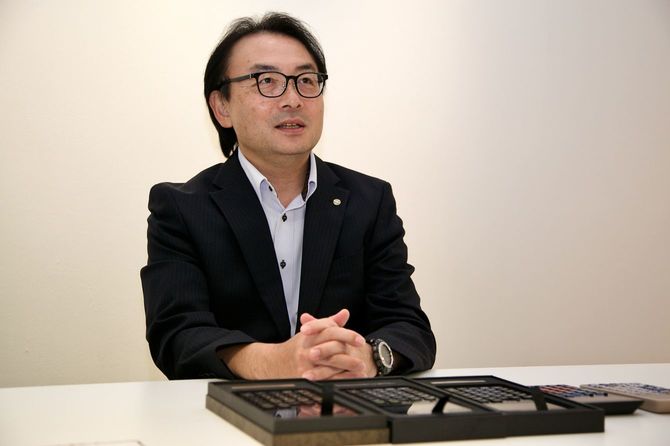 佐藤智昭・教育事業部長。約10万円の漆電卓プロジェクトを主導した