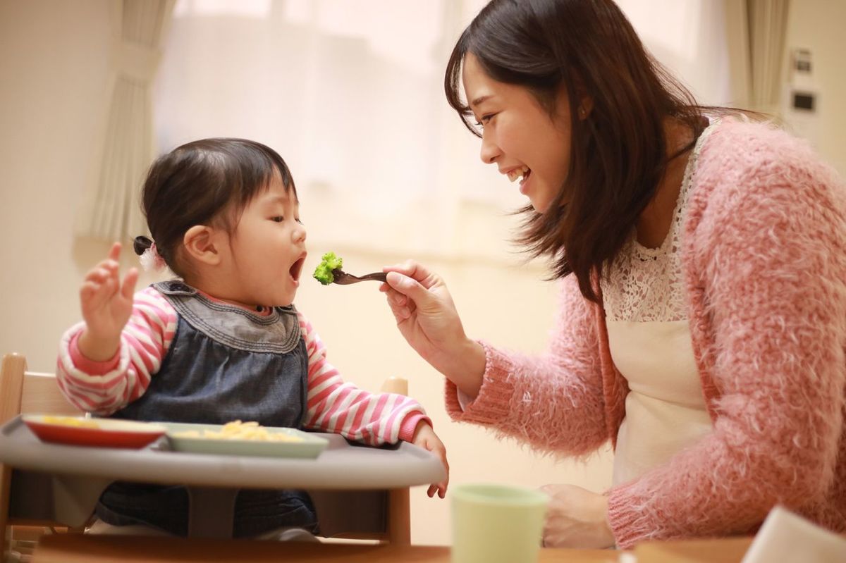 子どもにごはんを食べさせる女性