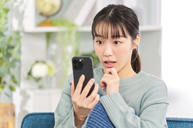 スマホを見て驚く女性