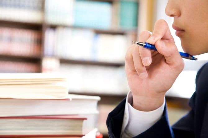 図書館で勉強する男子中学生