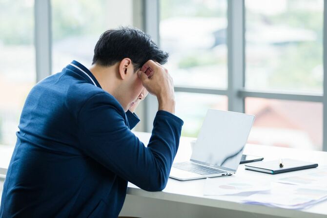 ラップトップ作業でストレスを受けたビジネスマン