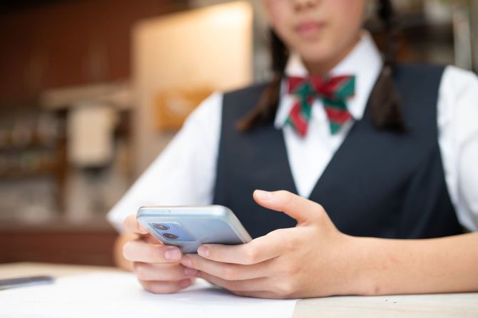 スマートフォンに目を落としている女子生徒