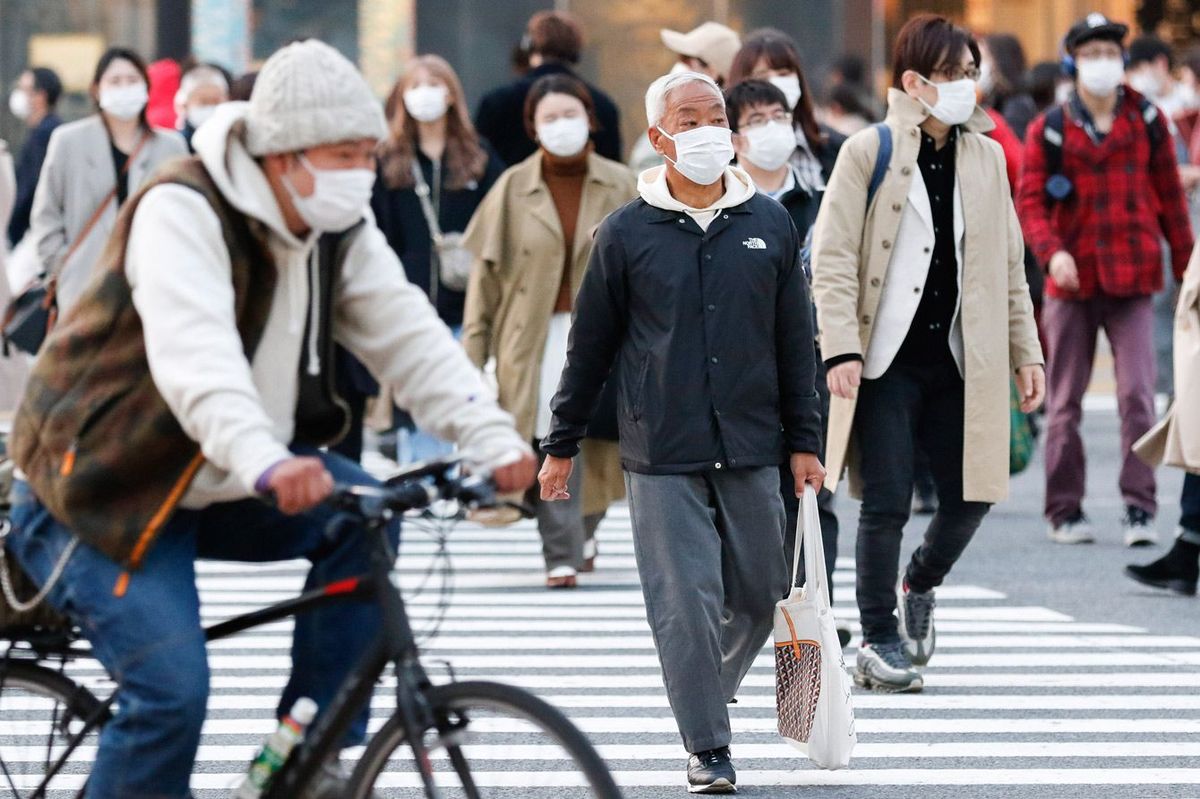 コロナウイルスが流行しマスクをつけて歩く東京の人々