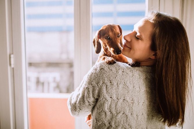 ダックスフントを抱く女性
