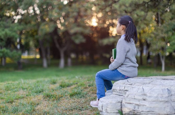 本を抱えて待つ少女