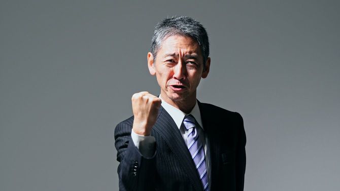 こぶしを握り締めポーズをとるシニア男性