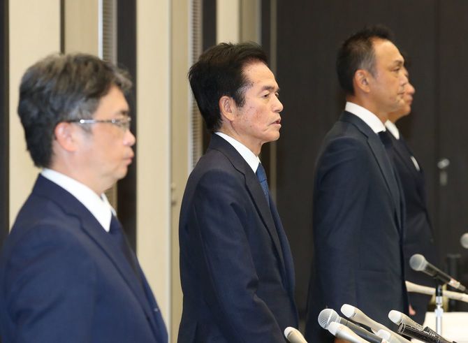 記者会見の終了前、起立して話す中古車販売大手ビッグモーターの兼重宏行社長（中央）ら＝2023年7月25日午後、東京都港区