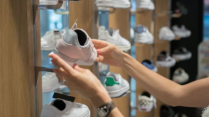 靴屋でスニーカーを選ぶ女性