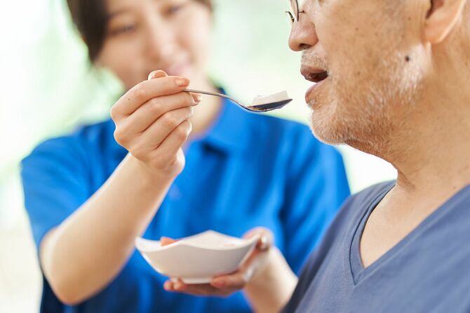 高齢者の食事を支援する介護者
