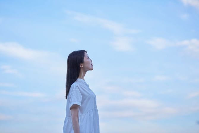 夕暮れ時の青空と白いドレスを着た女性