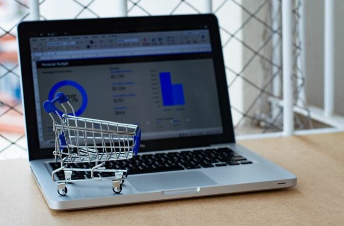 ECサイトの実績を表示するラップトップと買い物カート