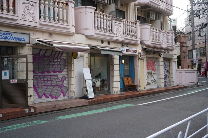 代官山駅から徒歩5分のテナントビル。シャッターが下りている店舗が多く、落書きで埋め尽くされている