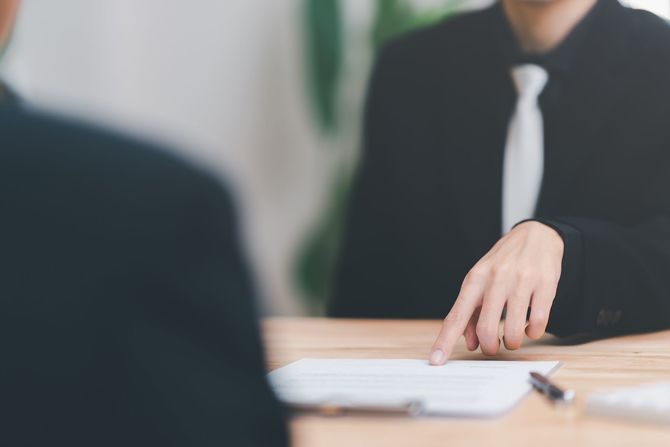 書類を指さすビジネスマン