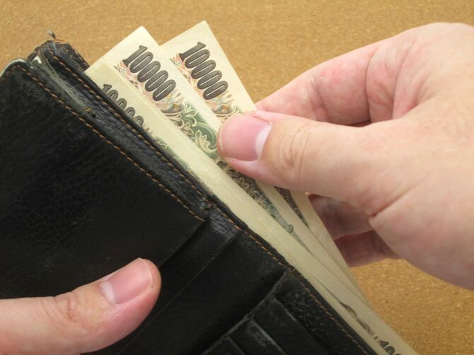 財布から複数の1万円札を取り出す手元