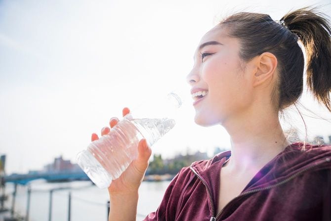 野外で水を飲む女性