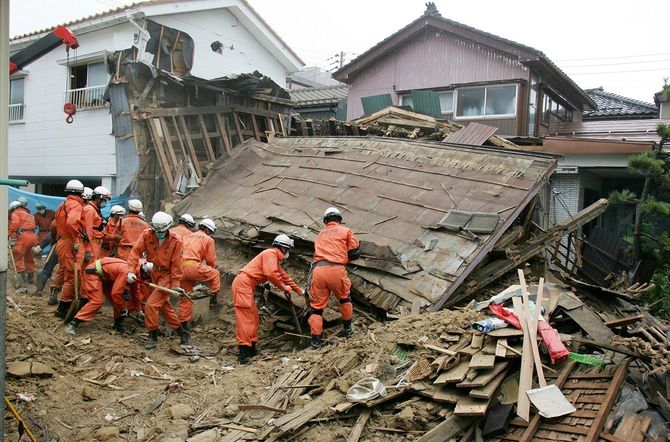 倒壊した家屋の下に、行方不明者がいないか捜索する消防隊員