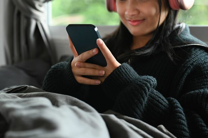 寝室でオンラインチャットをする10代の女の子