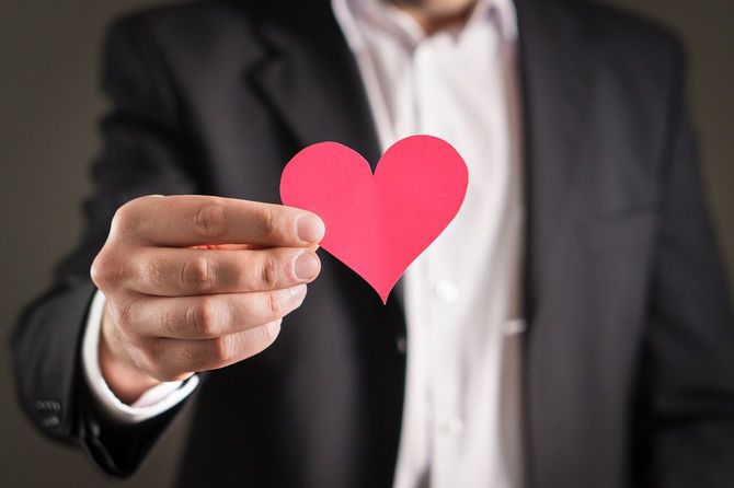 ハートマークの紙片を差し出す男性
