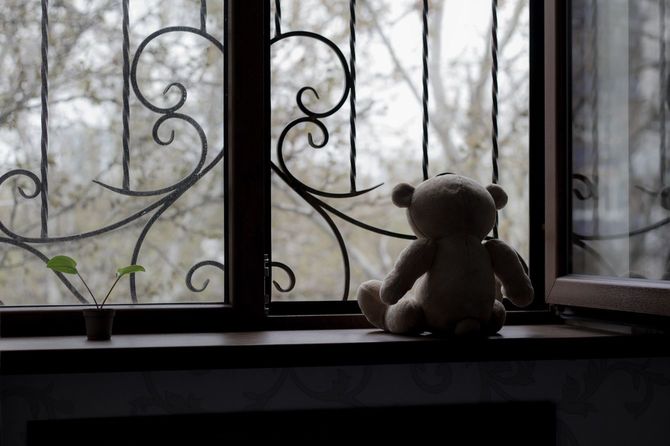 窓辺に置かれたクマのぬいぐるみ