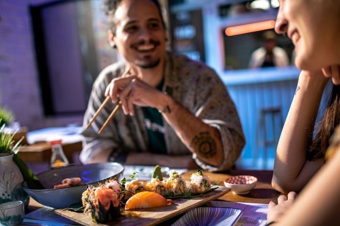 地元の寿司店で寿司を楽しむ若いカップル