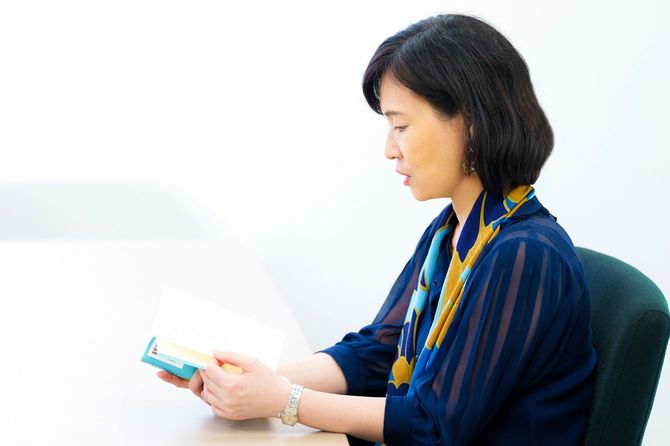 書籍を手に取りながら内容について語る河合さん