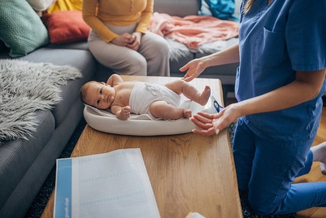 訪問医の女医が新生児の女児を診察中